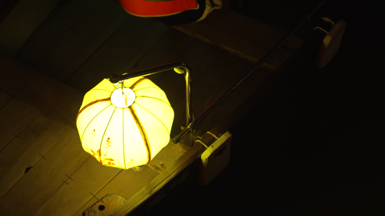 Dark and moody shot of a yellow light reflecting off a chair in Vietnam
