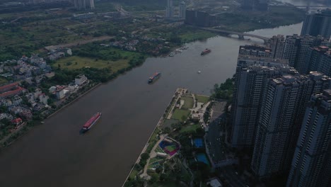 landmark and surrounding high rise buildings, saigon river with container boats