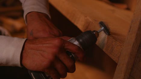 A-woodworker-sands-the-shelves-of-a-wooden-bookshelf