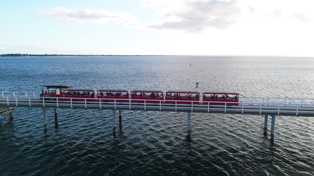 Drone following train along Busselton Jetty at sunset