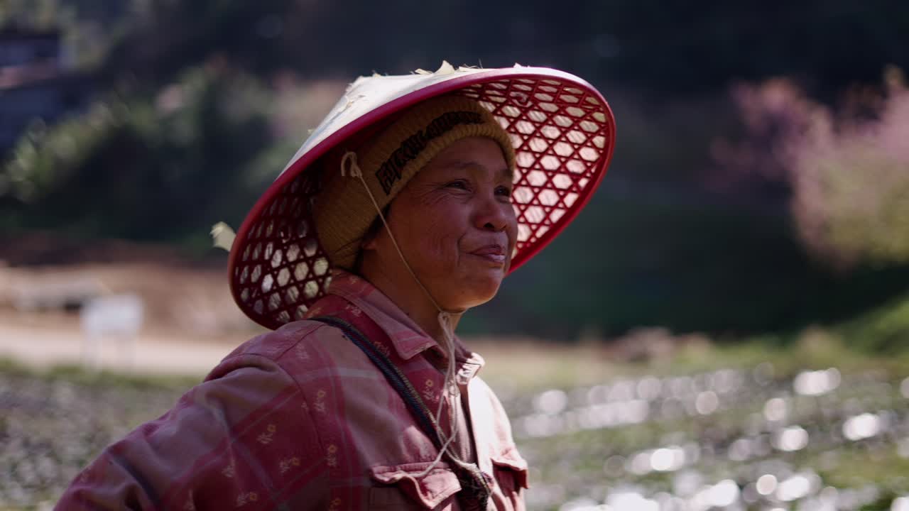 Portrait of a farmer in a conical hat in a field