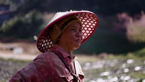portrait of a farmer in a conical hat in a field