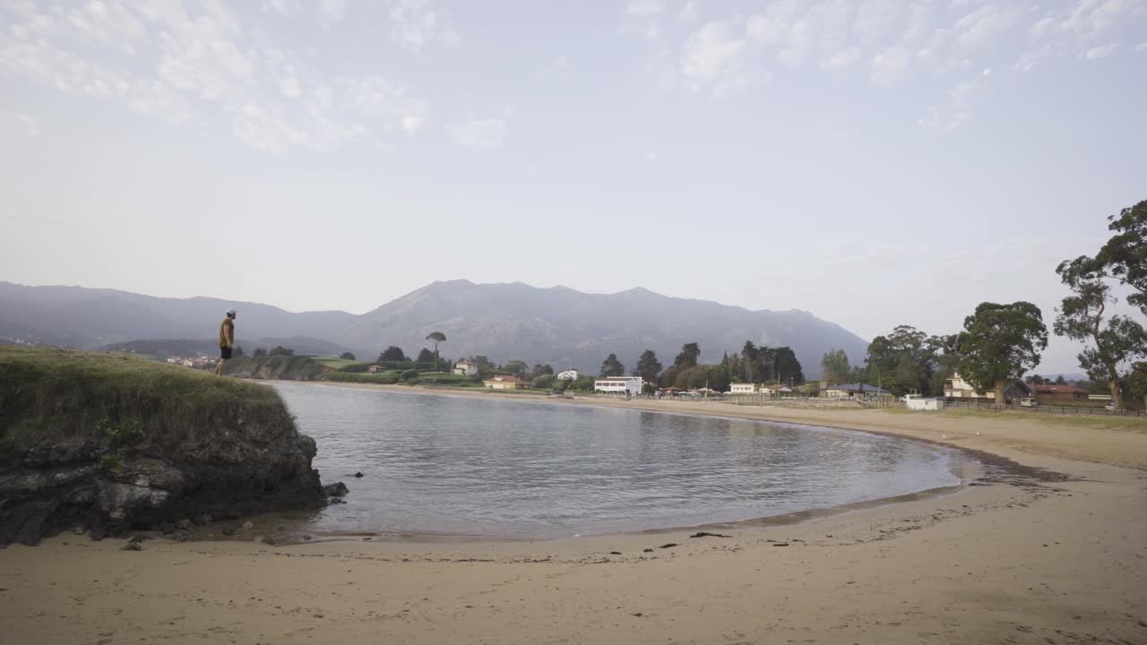 hombre corriendo en la costa, playa, montañas al fondo, océano, cielo despejado, asturias, españa, tiro estático