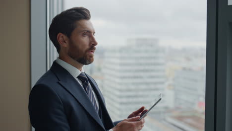 Unternehmer-Plant-Tablet,-Das-Am-Bürofenster-In-Der-Nähe-Steht.-Mann-Denkt-Nach