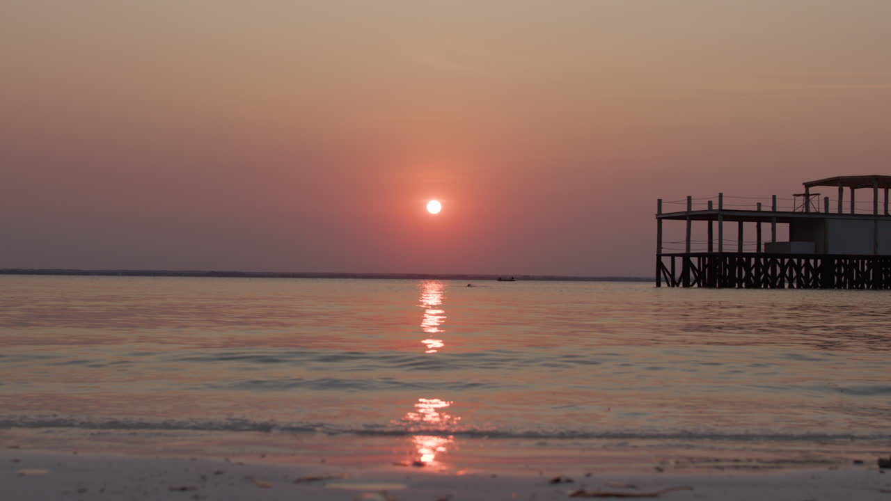 Sunset over the ocean with a pier