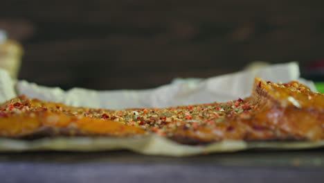 pedazo de pescado de trucha ahumado con diferentes especias en papel