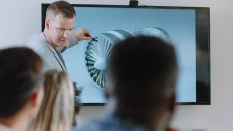 business people meeting in boardroom engineer man presenting turbine design on tv screen sharing technical briefing with colleagues discussing ideas in office presentation