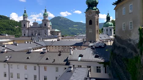 tilt up shot showing historical churches and cathedral in salzburg in front of mountains