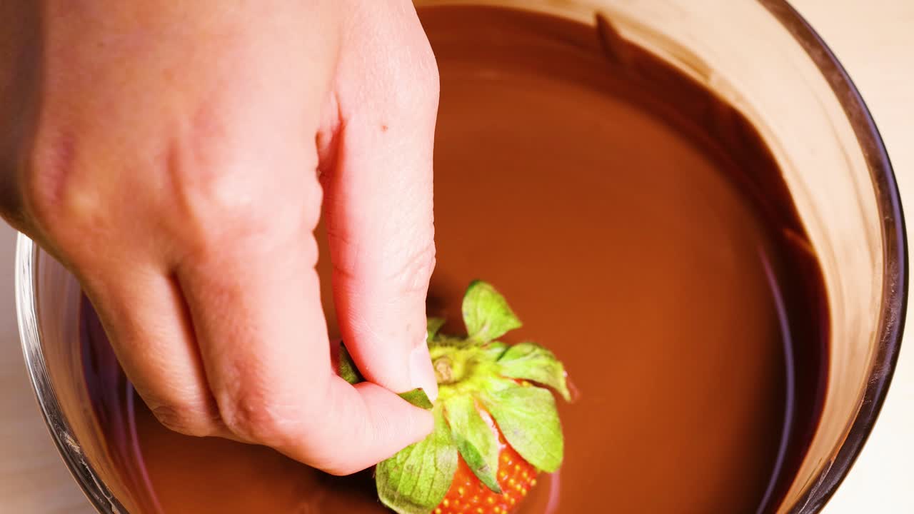 녹은 초콜릿 에 딸기 를 담그고 있는 것