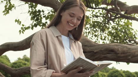 woman reading funny book on tree