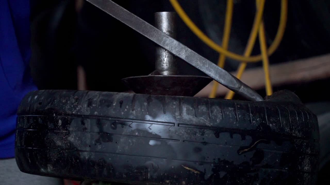 primer plano del proceso de extracción del neumático del automóvil del cambiador de neumáticos de uso de llanta