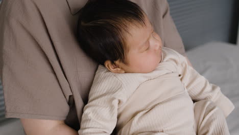 baby sleeping in parent's arms