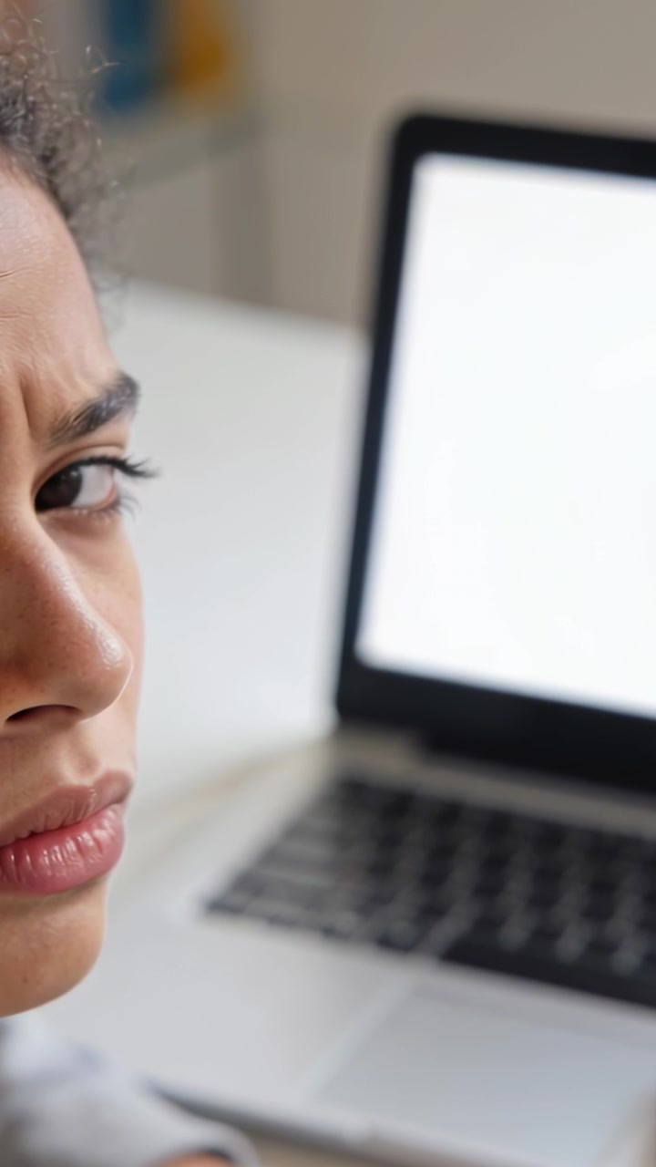 Vertical video: Reacting to camera shift, student checking blank laptop screen at desk, copy space