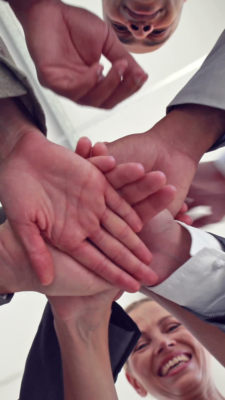 Business colleagues putting their hands together