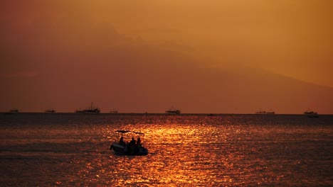 beautiful shot of boat going past sunset in manila philippines