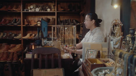 asian man working on computer in antique store