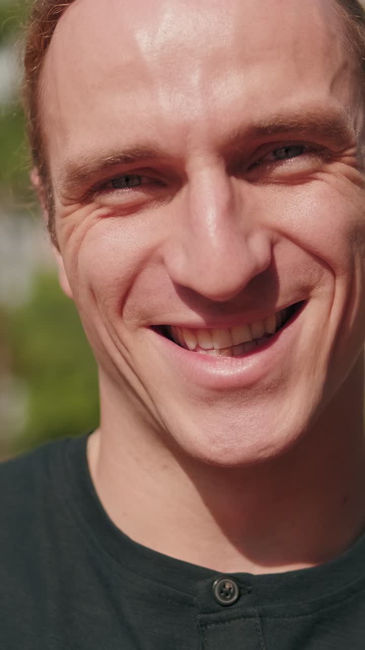 Close up portrait of handsome European young man smiling, male student outdoors