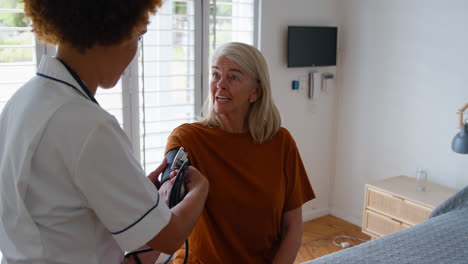 Krankenschwester-In-Uniform-Misst-Den-Blutdruck-Einer-älteren-Frau-Im-Privaten-Krankenzimmer