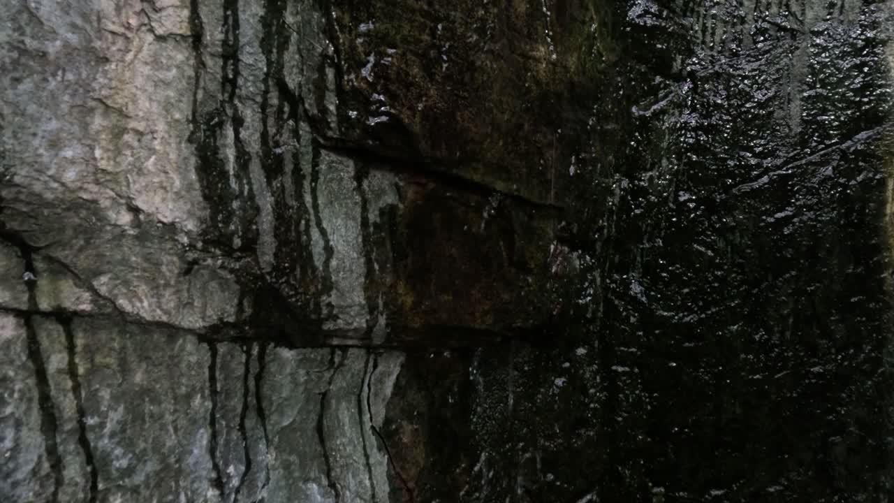 primer plano del agua que fluye por una roca de textura