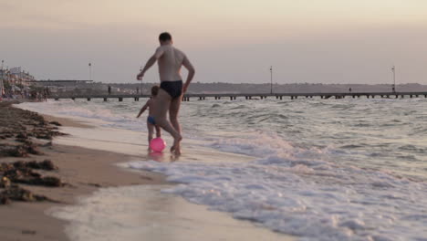 Padre-E-Hijo-Corriendo-Por-La-Playa-Con-Pelota