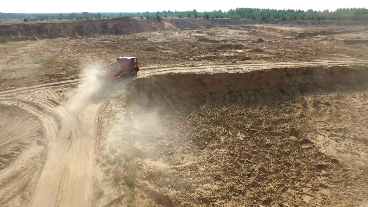 vista aérea de camiones y polvo en una cantera