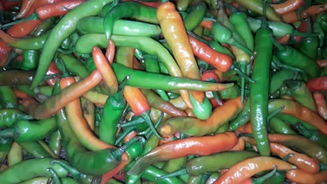 un montón de chiles rojos y verdes en el estante de la tienda en el supermercado
