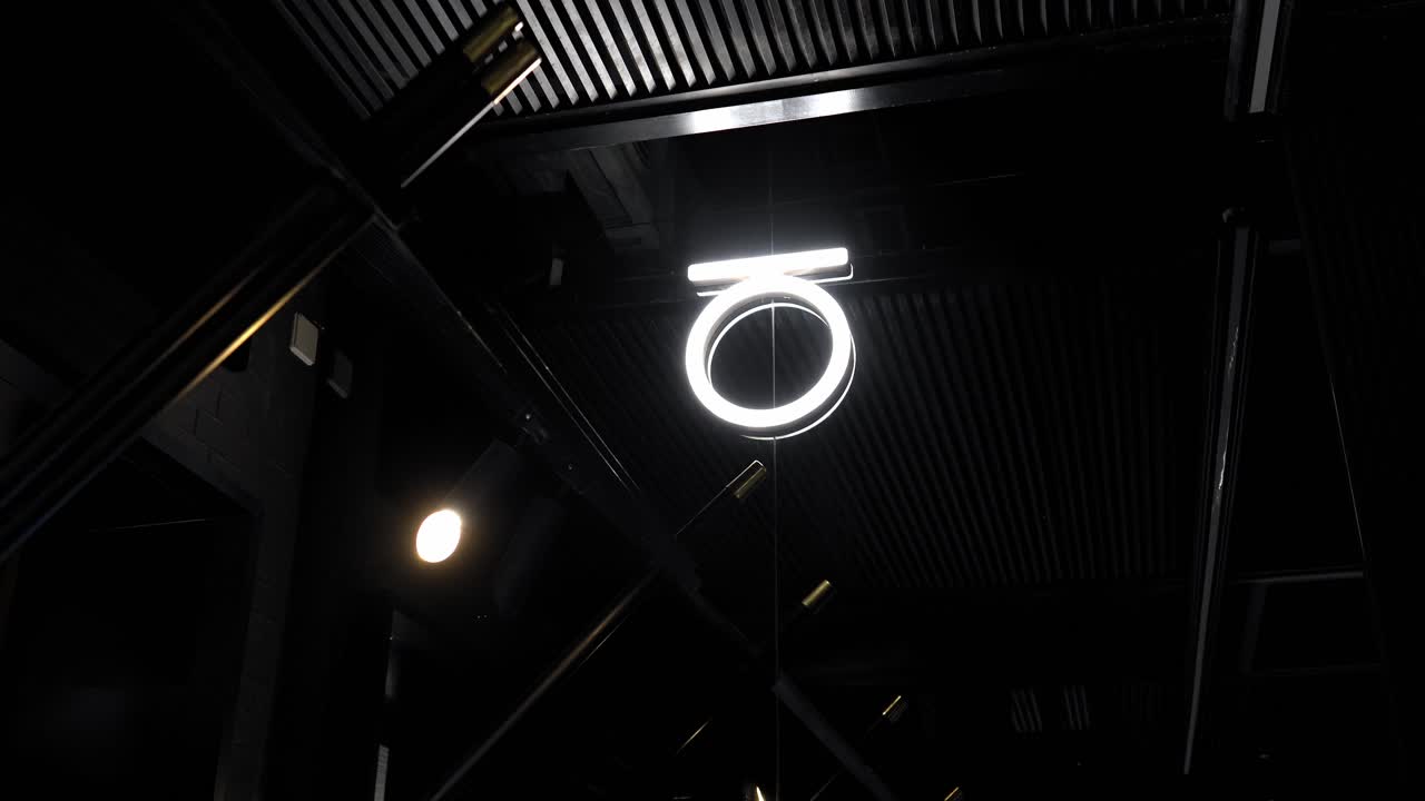 un letrero decorado con iluminación en un lugar al aire libre cerca de la toma, inclinación derecha, inclinación izquierda