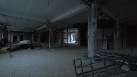 large spacious room with columns. some debris and scaffolding are scattered by the premise.