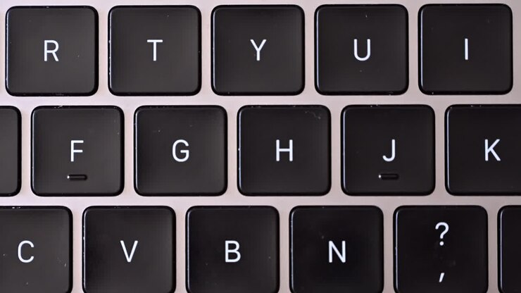Close up of a black keyboard on a silver laptop