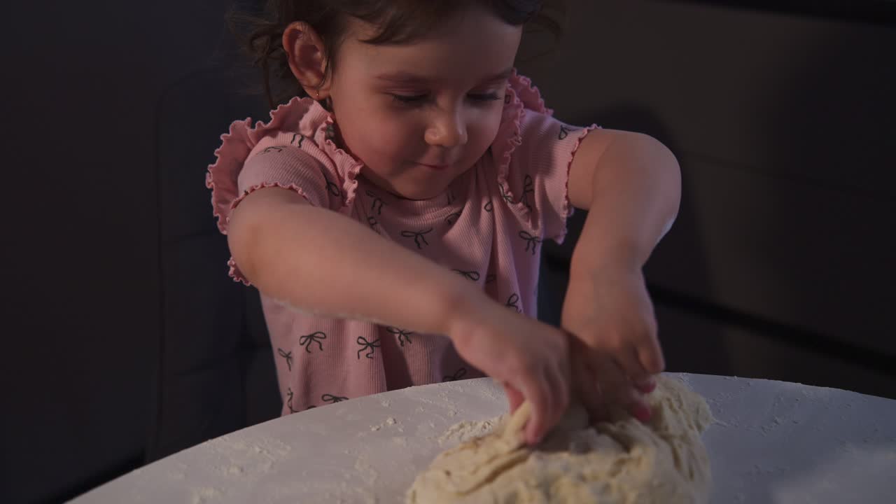 Cute Toddler Girl Kneading Dough on a Floured Table