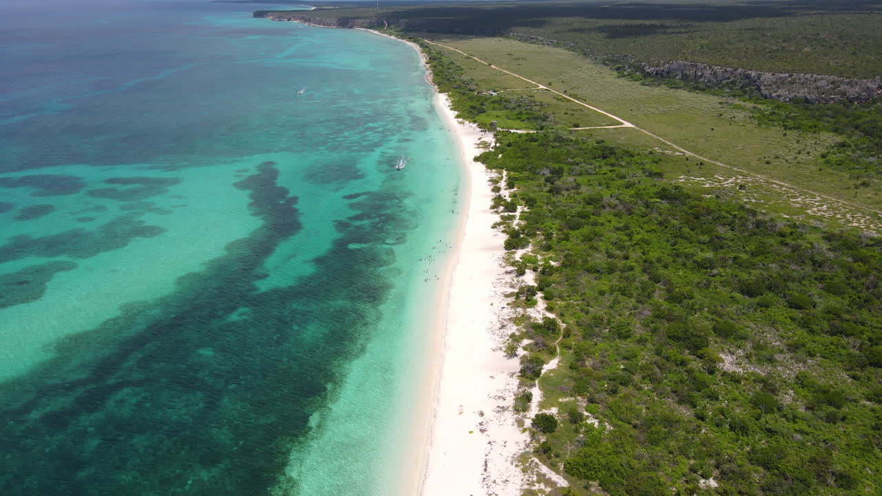Green island with sandy beach and clear Caribbean sea water and coral reefs