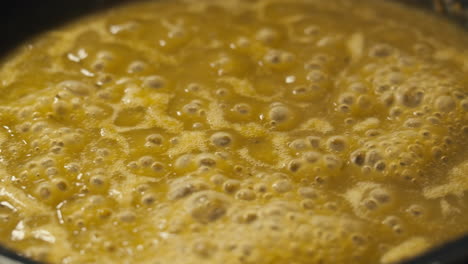green boiling sauce texture close-up macro. cooking green curry with wooden spoon at home.