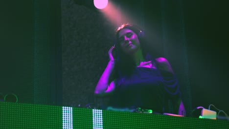 DJ-on-stage-in-disco-night-club-mixing-techno-music-beat