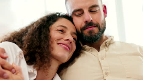 una pareja feliz se abraza y se relaja en un sofá en casa