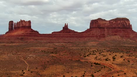 Imágenes-Aéreas-De-Las-Enormes-Colinas-De-Arenisca-En-El-Desierto-De-Arena-Roja-De-Arizona,-Que-Ofrecen-Una-Descripción-General-Del-Paisaje-Icónico-Del-Parque-Tribal-Navajo-Del-Valle-Del-Monumento