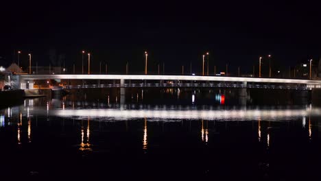 Beleuchtete-Brücke-über-Den-Fluss-Aare-In-Dunkler-Nacht-Mit-Wasserspiegelung-In-Der-Schweiz