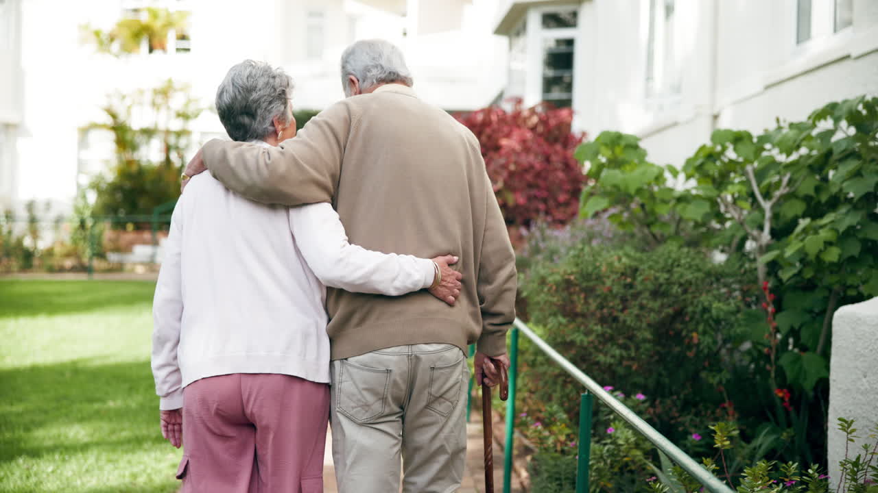 Elderly couple walking together in a garden