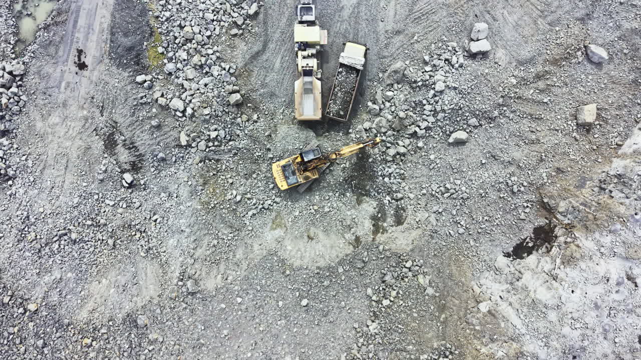 Granite quarry activity showing machinery and raw materials in a mining site