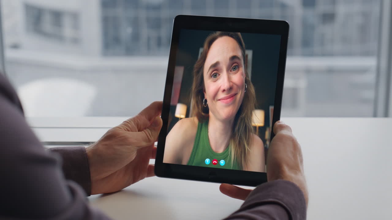 Uomo che flirta durante una video chat vicino a grandi finestre, primo piano.