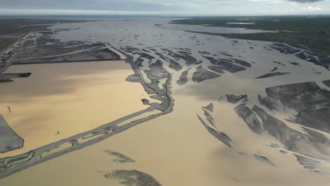 Glacier-muddy-river-streams-into-ocean-through-it´s-own-dynamic-pattern