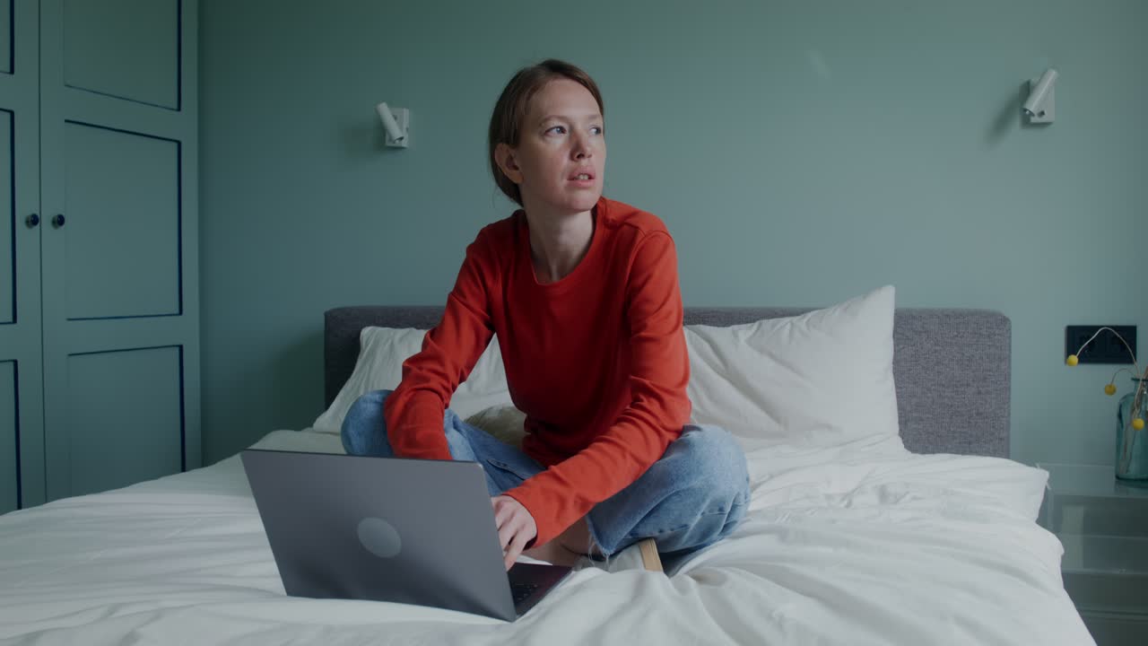 침실에서 노트북으로 일하는 여자