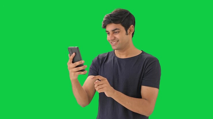 hombre indio feliz usando pantalla verde del teléfono