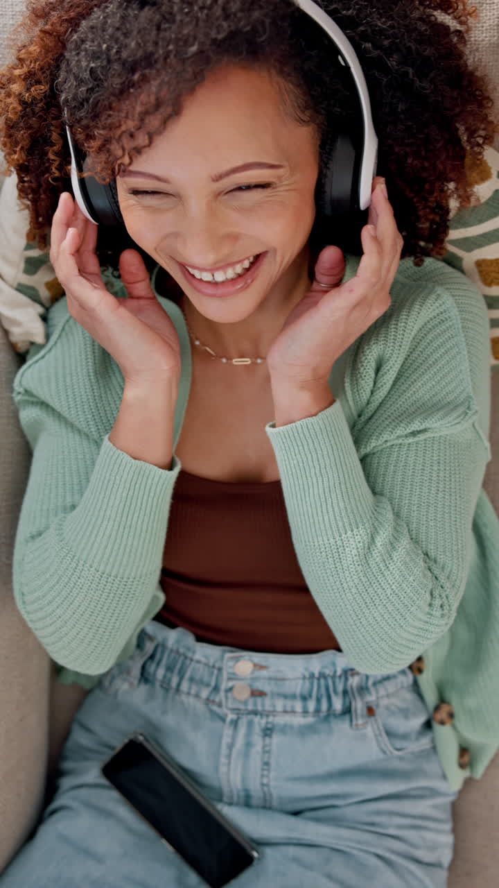 Donna felice che ride mentre ascolta la musica con le cuffie