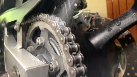 oiling a motorcycle chain in a workshop