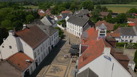 Panning-drone-shot-in-the-heart-of-the-municipality-of-Maasgouw,-Thorn,-Limburg-with-view-of-beautiful-historic-buildings-in-Dutch-architecture-and-the-landscape-in-the-background
