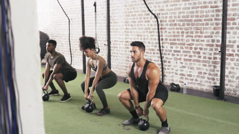 three people using kettle bells  while working out