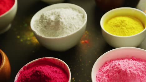 video of multi coloured powder in bowls with copy space on black background