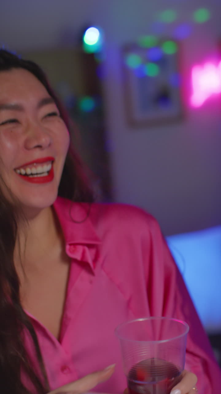 video vertical de una pareja divirtiéndose bailando y bebiendo alcohol en una fiesta en casa juntos