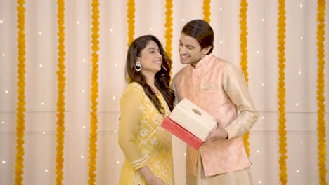 mujer india dando regalos a su marido en el festival