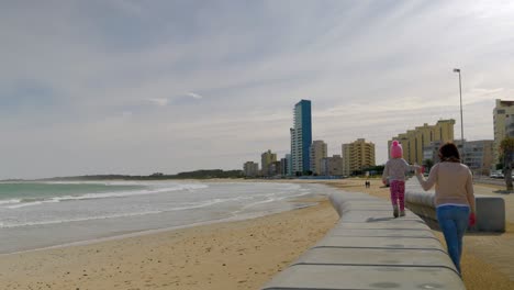 Mamá-Con-Un-Niño-Lindo-Caminando-Juntos-En-El-Paseo-Marítimo-De-La-Mano